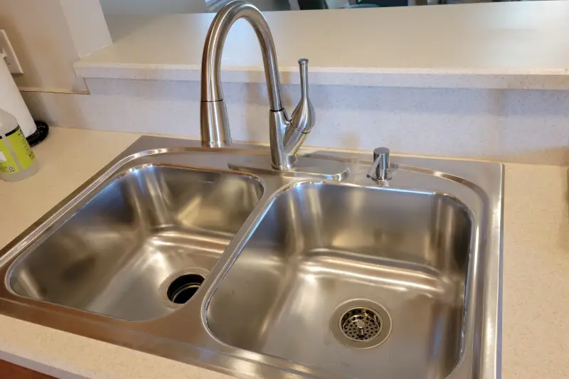 A sleek stainless steel sink reflecting light, showcasing its modern design and polished surface